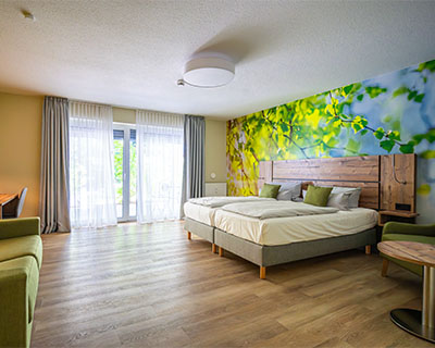 Hotelzimmer im Hotel Anders mitDoppelbett und grünen Akzenten