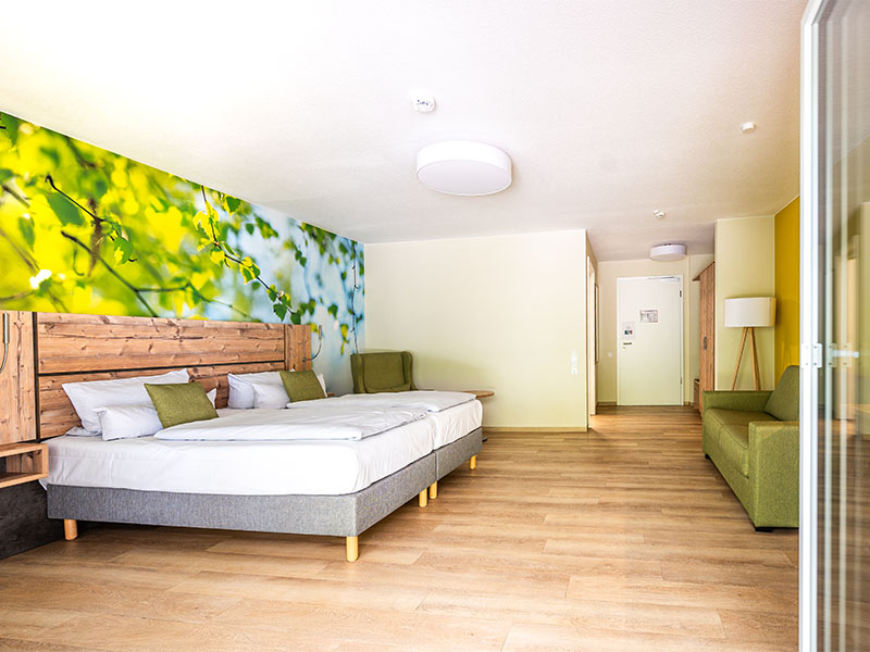 Hotelzimmer im Hotel Anders mit Doppelbett mit grünen Akzenten