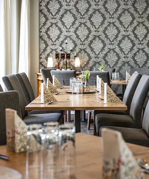 Speisesaal mit grauen Stühlen und gedecktem Tisch