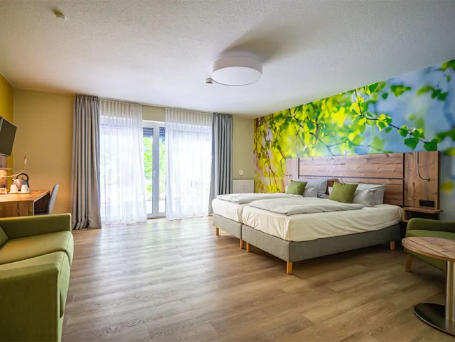 Hotelzimmer im Hotel Anders mit Doppelbett und grünen Akzenten