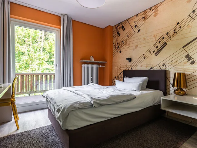 Hotelzimmer im Hotel Anders mit Einzelbett und Tapete mit Noten